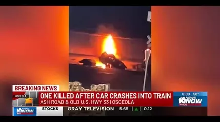 Person killed after fiery car crash into train