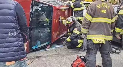 Fire crews pull driver from flipped car in Ballard